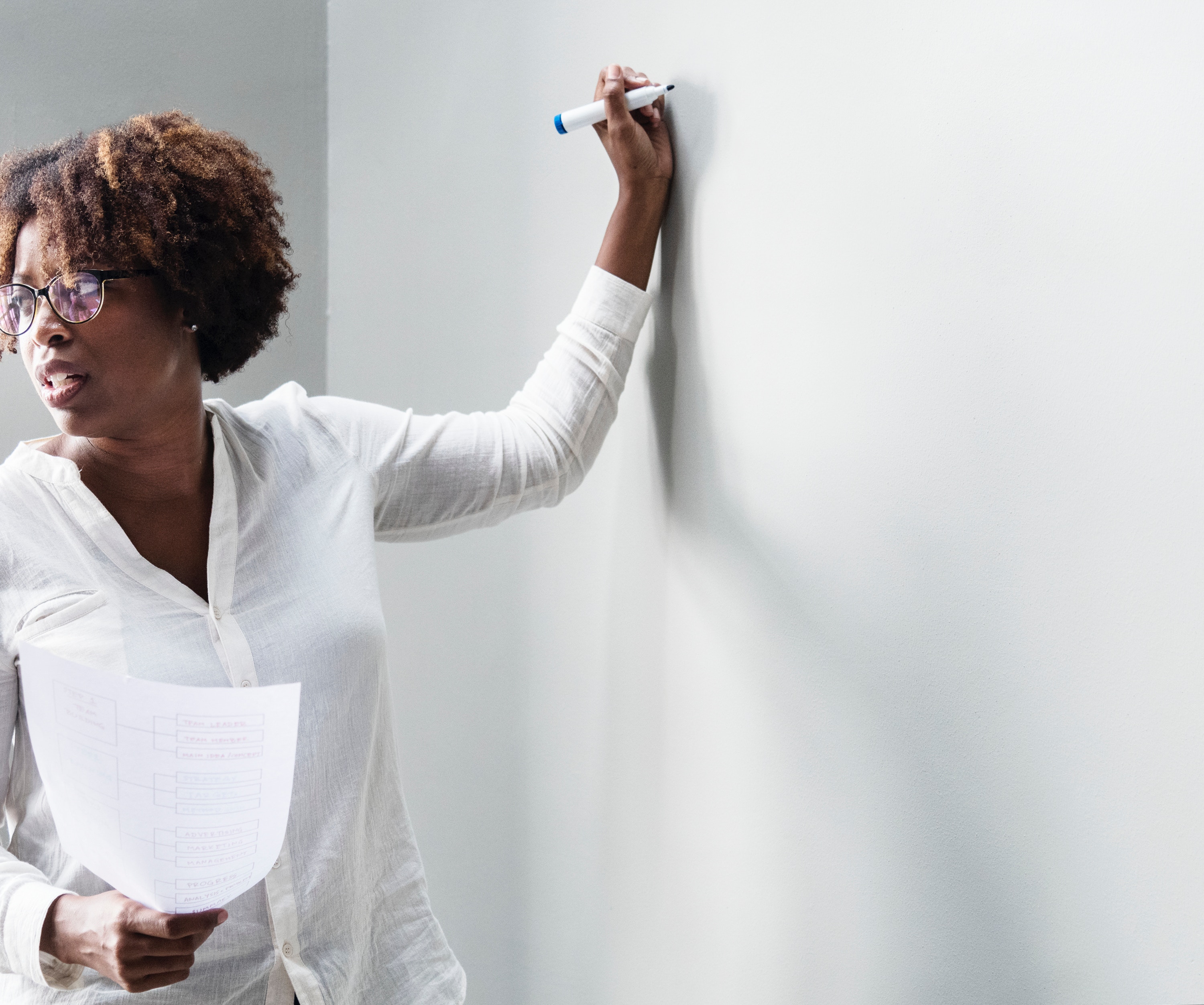 woman writing on whiteboard marketing goals